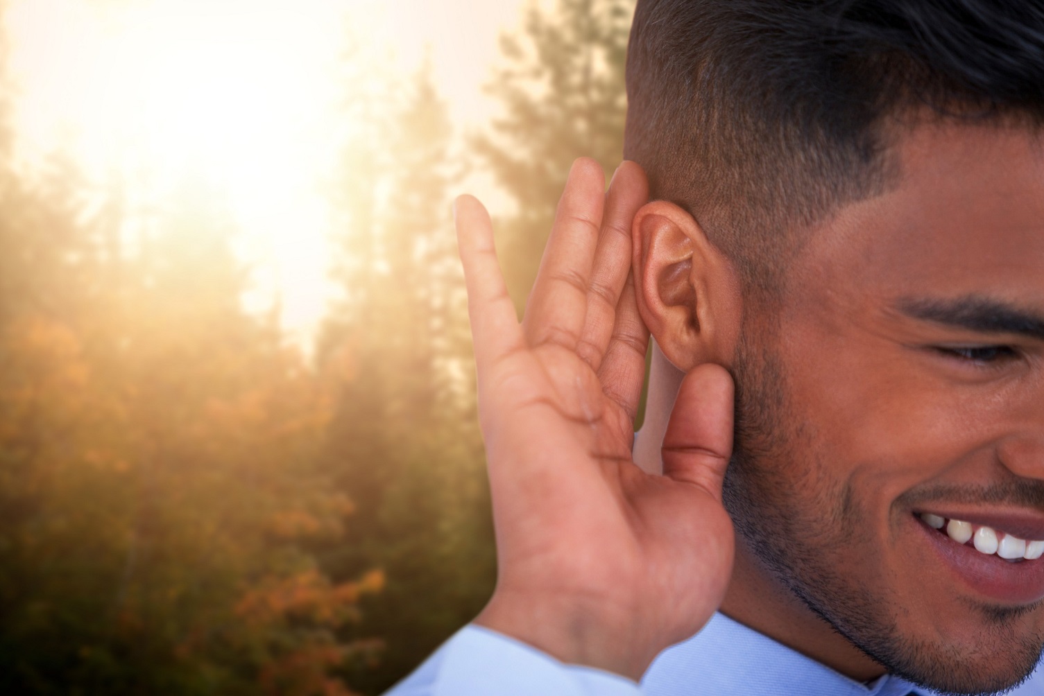 man with hand to ear listening